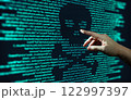 Human hand points at abstract Modern tech of Programming code screen with skull. Computer Virus, Malware, and Hacker Attack Concept. 122997397