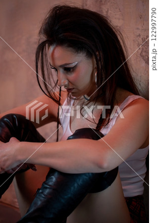 A thoughtful woman in stylish leather boots, exuding confidence and a chic attitude A thoughtful woman in stylish leather boots, exuding confidence and a chic attitude 122997790