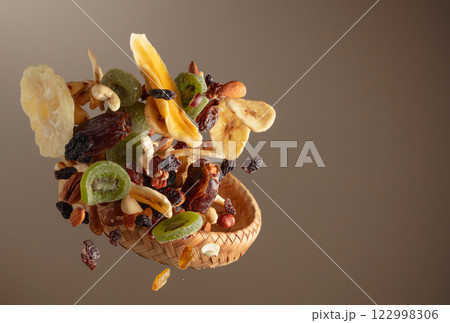Dried tropical fruits with various nuts and raisins in motion. 122998306