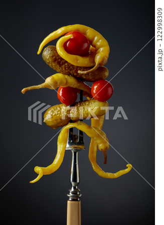 Canned yellow peppers, cucumbers, and tomatoes on a black background. Canned yellow peppers, cucumbers, and tomatoes on a black background. 122998309