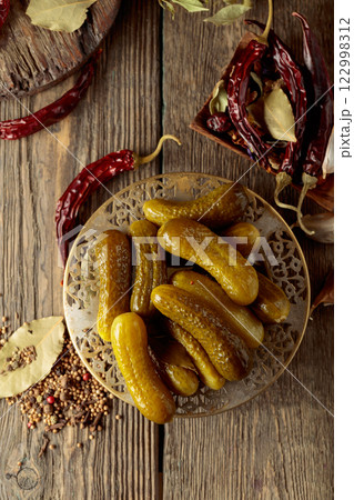 Pickled cucumbers with ingredients on an old wooden table. 122998312