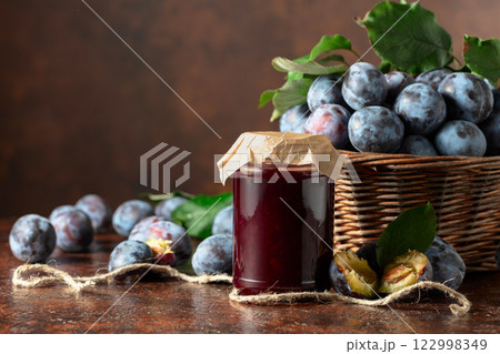 Plum jam and fresh berries on a brown vintage table. Plum jam and fresh berries on a brown vintage table. 122998349