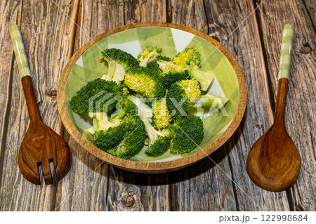 Broccoli dish with wooden spoons.  122998684