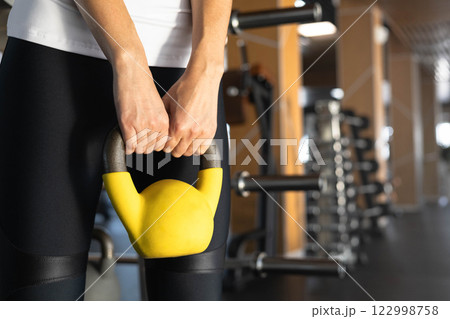 Athletic bodybuilding sport woman squat with kettlebell fitness training at gym. 122998758