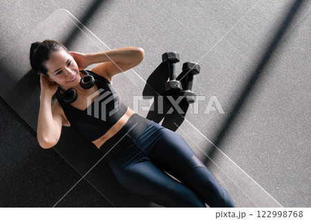 Beautiful athletic Asian woman trains in gymnastics studio, enjoys flexibility, healthy lifestyle 122998768