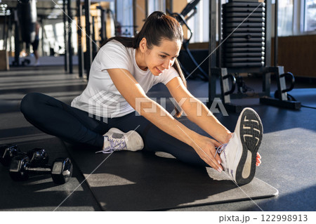 Athletic fitness Asian woman stretching body at gym enjoy physical exercise activity 122998913
