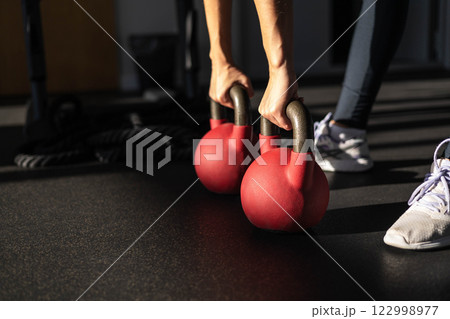 Athletic bodybuilding sport woman squat with kettlebell fitness training at gym. 122998977
