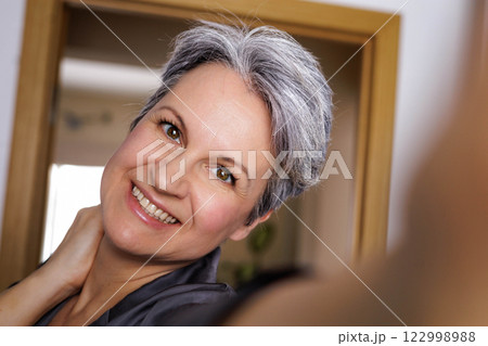 An adult well-groomed beautiful woman of age during menopause with gray hair takes a selfie An adult well-groomed beautiful woman of age during menopause with gray hair takes a selfie 122998988