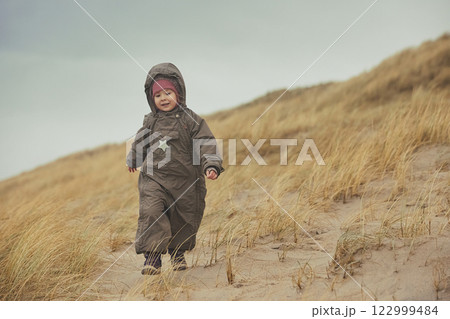 Adorable child playing in the grass in Denmark Adorable child playing in the grass in Denmark 122999484