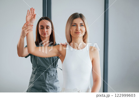 Working with arms. Woman is in health center getting help by doctor Working with arms. Woman is in health center getting help by doctor 122999603