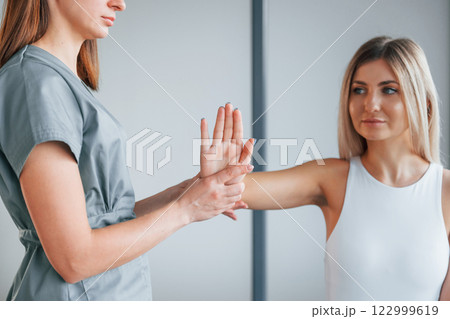 Moving the hand. Woman is in health center getting help by doctor 122999619