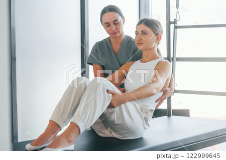 Doing abs. Woman is in health center getting help by doctor Doing abs. Woman is in health center getting help by doctor 122999645