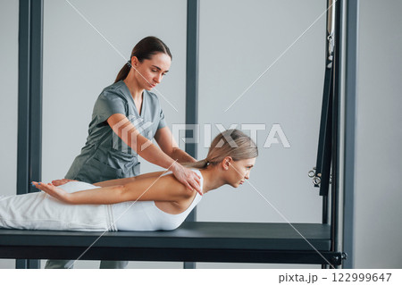 Laying down on stomach. Woman is in health center getting help by doctor Laying down on stomach. Woman is in health center getting help by doctor 122999647