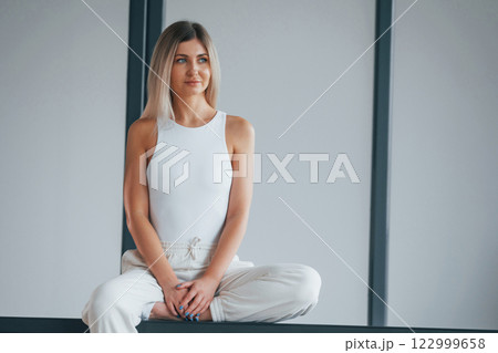 Woman in sportive clothes is standing in the studio 122999658