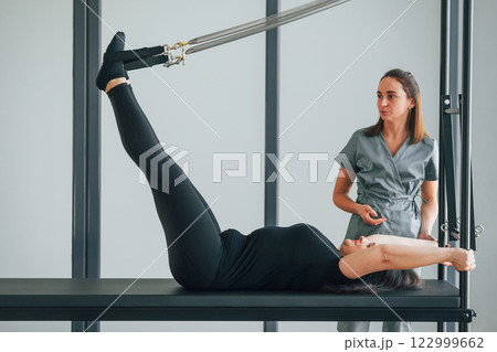 Active exercises. Woman is in health center getting help by doctor Active exercises. Woman is in health center getting help by doctor 122999662