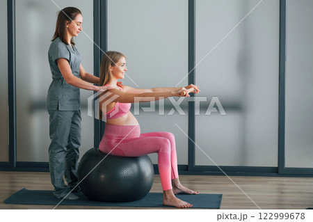 Pregnant woman is in health center getting help by doctor 122999678