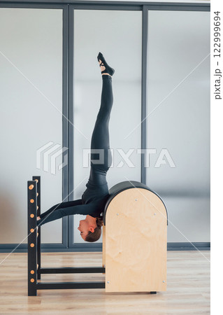Doing tricks. Woman in sportive clothes is in the studio 122999694