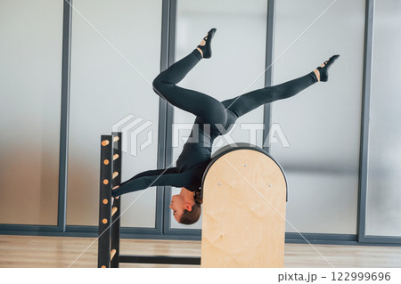 Doing tricks. Woman in sportive clothes is in the studio Doing tricks. Woman in sportive clothes is in the studio 122999696