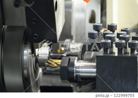 The  multi tasking CNC lathe machine swiss type drilling the metal fitting parts. 122999705