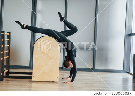 Using special equipment. Woman in sportive clothes is in the studio Using special equipment. Woman in sportive clothes is in the studio 123000037