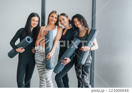 Friends is in the gym together. Women in sportive clothes standing in the fitness center 123000048
