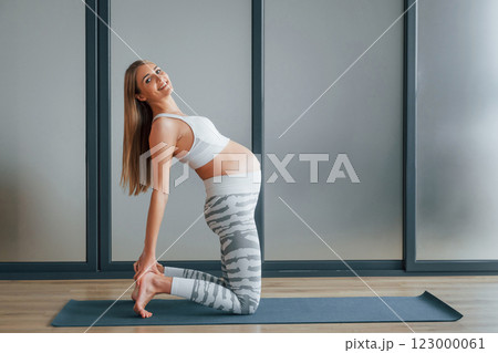 Pregnant woman in sportive clothes is in the studio 123000061