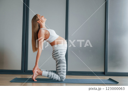 Pregnant woman in sportive clothes is in the studio 123000063