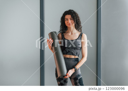 Standing and posing. Woman in sportive clothes is in the studio 123000096