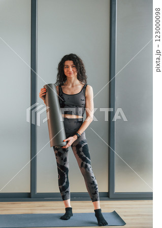 Standing and posing. Woman in sportive clothes is in the studio Standing and posing. Woman in sportive clothes is in the studio 123000098