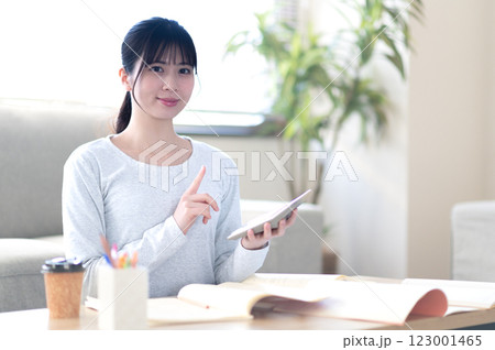 リビングで一人で勉強する若い女性 リビングで一人で勉強する若い女性 123001465