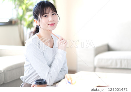 リビングで一人で勉強する若い女性 リビングで一人で勉強する若い女性 123001471