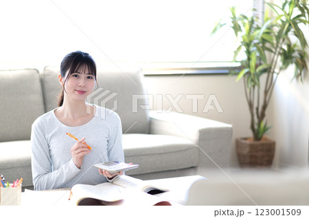 リビングで一人で勉強する若い女性 123001509