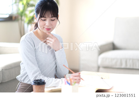 リビングで一人で勉強する若い女性 リビングで一人で勉強する若い女性 123001551