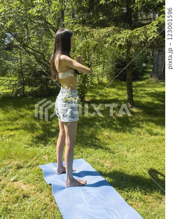 Side view of young woman doing yoga in the park Side view of young woman doing yoga in the park 123001596