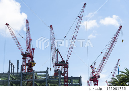 Low-angle view of cranes and steel structures of building construction with a blue sky background in Taiwan. Low-angle view of cranes and steel structures of building construction with a blue sky background in Taiwan. 123001786