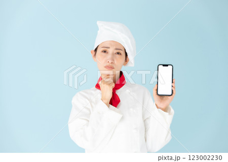 女性　シェフ　コックコート　スマホ　悩む 123002230