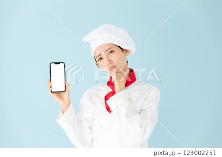 女性　シェフ　コックコート　スマホ　悩む 123002251