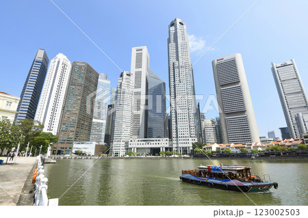Panoramic view of the Sightseeing Bumboats cruising on the Singapore River and the Financial District skyscrapers along the shore. 123002503