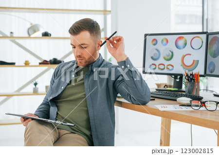With tablet in hands. Male designer working in the office by using PC With tablet in hands. Male designer working in the office by using PC 123002815