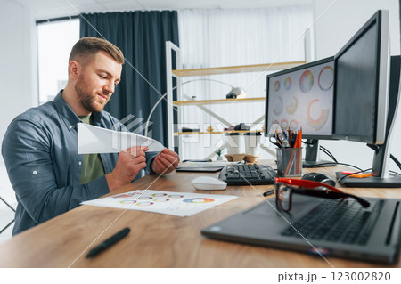 Creative occupation. Male designer working in the office by using PC 123002820