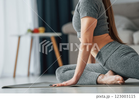Big stretches. Young woman with slim body type and in yoga clothes is at home 123003115