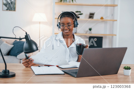 Freelance worker. Young african american woman in white shirt is at home 123003368
