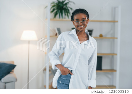 Domestic room. Young african american woman in white shirt is at home 123003510