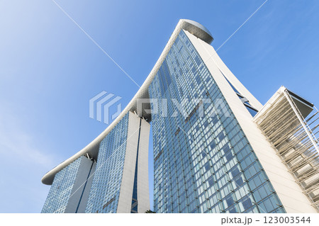 Building view of the Marina Bay Sands Hotel, Singapore, includes three towers topped by the Sands Skypark, a skyway, and an infinity-edge swimming pool.  123003544