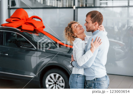 Embracing each other. Husband makes gift for his wife. Modern new car 123003654