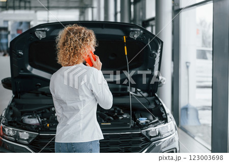 Modern technologies. Woman with curly blonde hair is in autosalon Modern technologies. Woman with curly blonde hair is in autosalon 123003698
