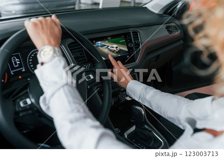 Doing test drive. Woman with curly blonde hair is in autosalon 123003713