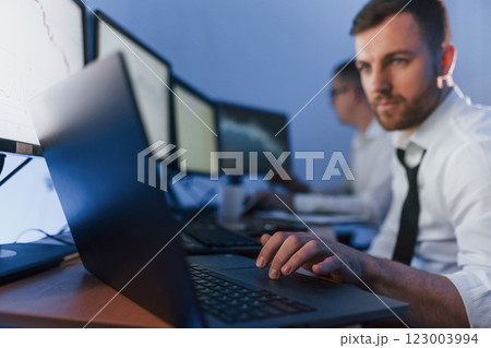 Using laptop. Two stock traders working in the office with exchange technology 123003994