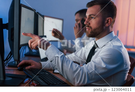 Side view. Two stock traders working in the office with exchange technology 123004011