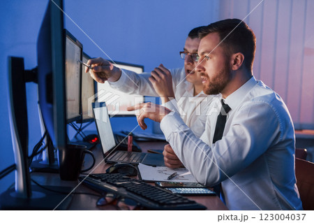 Stressful work. Two stock traders is in the office with exchange technology on monitors 123004037